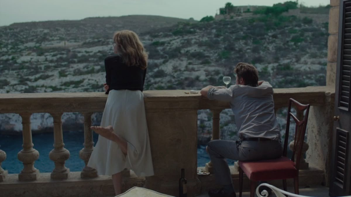 A couple sharing a quiet moment on a Mediterranean balcony